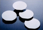 A group of four white discs sitting on top of a table.