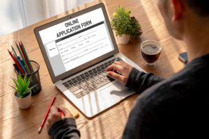 Person filling online application on laptop