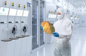 Technician in cleanroom inspecting silicon wafer